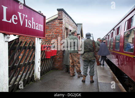 Zug aus dem 2. Weltkrieg in Levisham. North Yorkshire, Großbritannien. Oktober 2013. Deutsche Bahnhofswärter oder Feldgendarmerie bei der Veranstaltung ‘Railway in Wartime’ North Yorks Moors Railway (NYMR) am Wochenende 12.-13. Oktober 2013 im Bahnhof Levisham bei schlechtem Wetter. Levisham Station, wurde während des (NYMR) ‘Kriegswochenendes’ mit antiken Plakaten und französischen Schildern geschmückt, um ‘Le Visham’ in Nordfrankreich zu werden. Die Versammlung, eine Nachbildung eines französischen Dorfes, das vom Zweiten Weltkrieg, dem Zweiten Weltkrieg, dem Zweiten Weltkrieg, dem Zweiten Weltkrieg, deutschen Truppen, Stockfoto