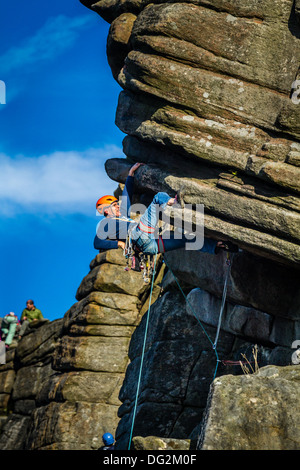 Männliche Kletterer Person eine Ferse Haken auf die Crux von Flying Buttress Direkte, Stanage, Peak District, Großbritannien Stockfoto