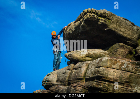 Männliche Kletterer Person, eine verschnaufpause vor dem letzten Zug auf Flying Buttress Direkte, Stanage, Peak District, Großbritannien Stockfoto