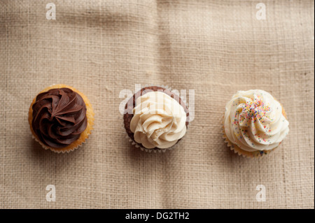 Drei Muffins mit Zuckerguss in Reihe, High Angle View Stockfoto