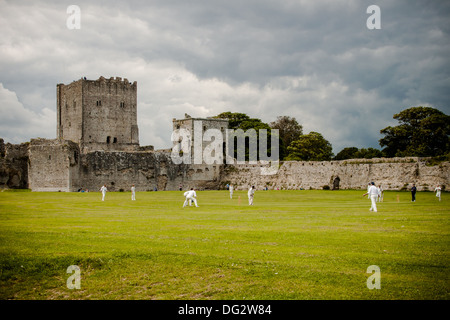 Fussball auf dem Gelände des Portchester Castle, Hampshire unter Gewitterhimmel Cricketers Stockfoto