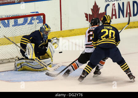 Rochester, New York, USA. 12. Oktober 2013. Michigans Steve Racine (1) sieht den Puck, während sein Teamkollege Travis Lynch (20) RIT Caleb Cameron (26) in der ersten Zeit gefesselt. Michigan besiegte RIT 7-4 Blue Cross Arena in Rochester, New York am 12. Oktober 2013 © Nick Serrata/Eclipse/ZUMAPRESS.com/Alamy Live News Stockfoto