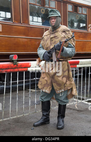 Weltkrieg, Zweiter Weltkrieg, Weltkrieg, WW2; Levisham. North Yorkshire, UK. 11. Oktober, 2013. Bob Fleming mit einem deutschen Soldaten bewacht die Bahn holidng ein MG34 machine gun auf die "Eisenbahn in Kriegszeiten "North Yorks Moors Railway (NYMR) Fall an Levisham Bahnhof. Levisham, war mit Postern dekoriert, und Französisch während der Kriegszeit (NYMR) 'Wochenende'' Le Visham zu werden' im Norden Frankreichs. Die Sammlung, die Erholung von einem französischen Dorf, das von deutschen Truppen besetzt, die Teil der "Allo Allo" - style unbeschwerte und lustige Stimmung. Stockfoto