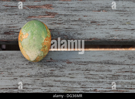 Ein einziges bemalte Ei, eingerichtet im traditionellen griechischen Stil, in grün und Orange, marmorierte saß auf alten bemalten hölzernen Planken, Stockfoto