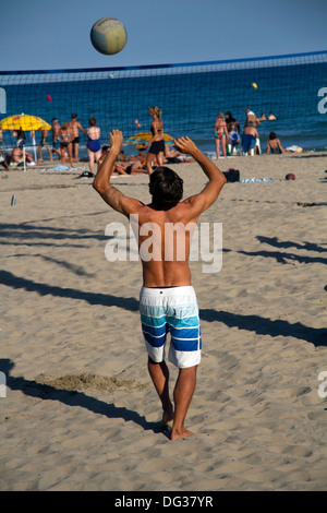 junge Menschen, die am Strand Volleyball spielen Stockfoto