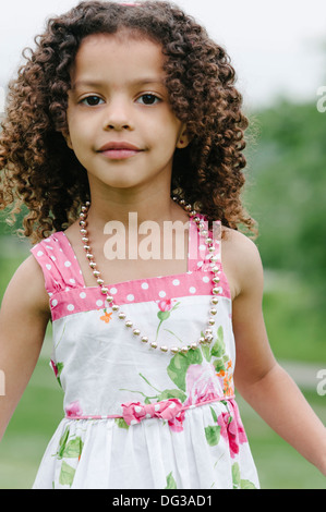 Junges Mädchen mit braunen Locken tragen Sommerkleid und Halskette, Porträt Stockfoto