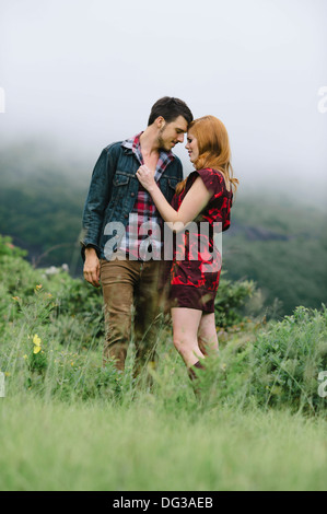 Romantisch zu zweit im nebligen Feld stehen Stockfoto