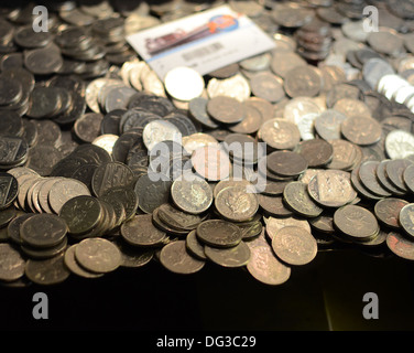 Münzen in Spielautomaten überhängend Stockfoto