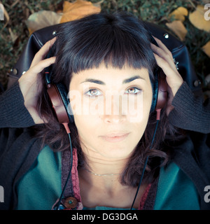 junge schöne Frau anhören von Musik im Park im Herbst Stockfoto