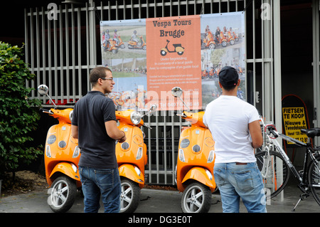 Zwei junge Männer in Brügge Belgien sucht im City Touren auf einer Vespa Roller Stockfoto