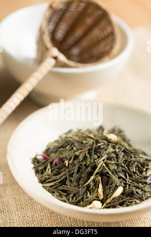 Grüne Teeblätter mit Trockenblumen Stockfoto