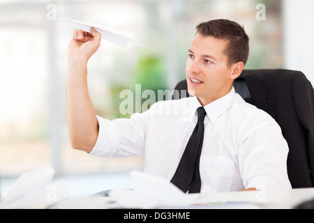 lächelnde Geschäftsmann mit Papierflieger im Büro spielen Stockfoto