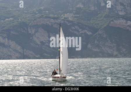 Paar Segelyacht am Gardasee, Italien. Yacht trägt italienische und deutsche Flaggen. Stockfoto