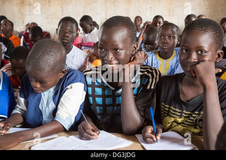 Senegal, Touba. Senegalesischen Studenten an Al-Azhar Madrasa, eine Schule für islamische Studien, schreiben in Arabisch in ihre Hefte. Stockfoto