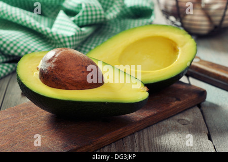 Frische Avocado auf Schneidebrett über hölzerne Hintergrund Stockfoto