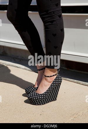 Frau mit schwarzen und weißen Tupfen Keil Plateau Heels - USA Stockfoto