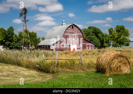 Eine rote Scheune und Windmühle in der Nähe von Zeeland, North Dakota, USA. Stockfoto