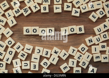 Plastische Buchstaben aus ein Kinder Rechtschreibung-Spiel auf einem Holztisch Zauber "gute Arbeit" Stockfoto