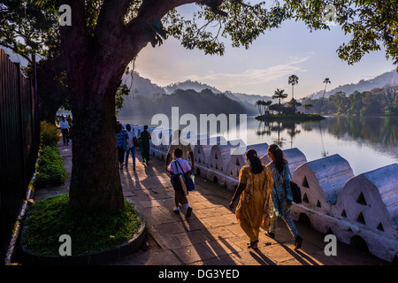 Bevölkerung Sri Lankas zu Fuß in Kandy Lake bei Sonnenaufgang, Kandy, Central Province, Sri Lanka, Asien Stockfoto