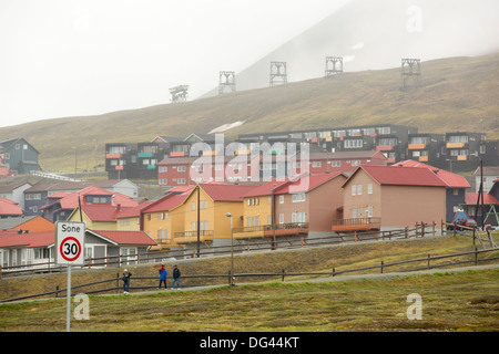 Gehäuse in Longyearbyen und Hauptstadt von Spitzbergen, Svalbard, mit einem alten Kohle-Aufzug im Hintergrund. Stockfoto