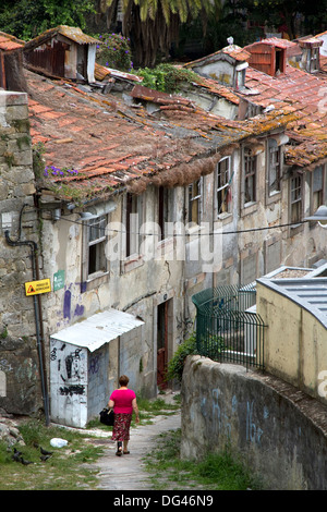 Frau zu Fuß vorbei an verlassenen Häusern in Bairro tun Barredo Viertel, Viertel Ribeira, zentral-Porto, Portugal Stockfoto