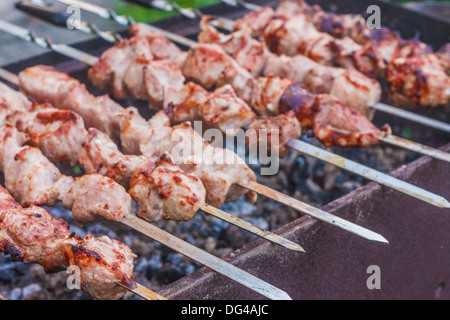 Saftige Scheiben von Fleisch mit Soße bereiten sich auf Feuer (Schaschlik). Stockfoto