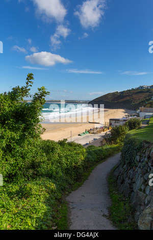 South West Coast Path Carbis Bay Cornwall England in der Nähe von St Ives mit Sandstrand und blauer Himmel an einem schönen sonnigen Tag Stockfoto