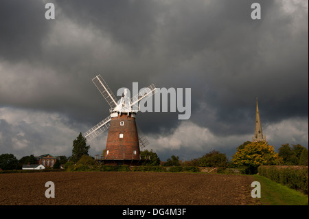 Thaxted, Essex, England. Juli 2013 hier gesehen: John Webbs Windmühle und Thaxted Kirche mit herbstlichen Gewitterhimmel. Stockfoto