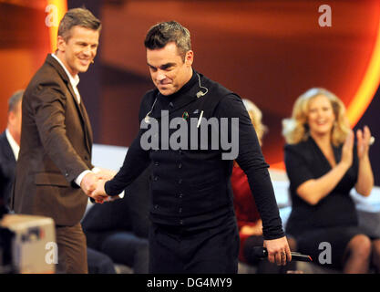 Deutsche Schauspielerin Barbara Schoeneberger (L) und deutsche TV-Moderatorin Markus Lanz (R) sprechen mit dem britischen Sänger Robbie Williams (C) während der ZDF-Spielshow "Wetten Das.? (will dass.?), gehostet von Markus Lanz (L) in der OVB-Arena in Bremen, Deutschland 3. November 2012. Foto: Ingo Wagner Stockfoto