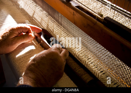 Traditionelle Weberei in Eddie Dohertys Tweed-Workshop in Ardara County Donegal Ireland. Hier threads Eddie einen shuttle Stockfoto