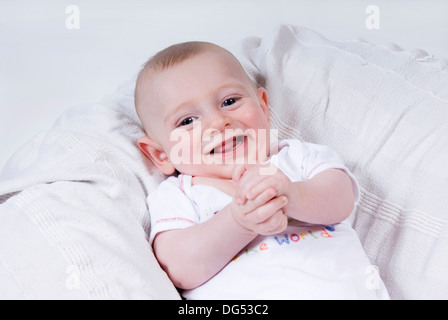 Nahaufnahme des Gesichts und der Hände eines lachenden lächelndes Baby jungen, UK Stockfoto