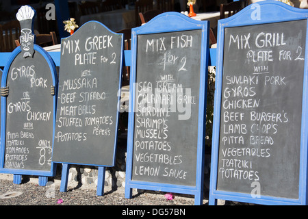 SANTORINI (THIRA), KYKLADEN, GRIECHENLAND. Tafel-Menüs außerhalb einer Taverne im Zentrum von Kamari. 2013. Stockfoto