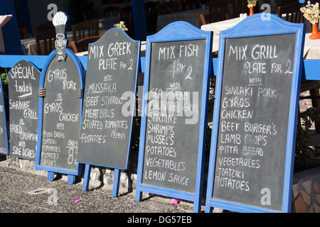 SANTORINI (THIRA), KYKLADEN, GRIECHENLAND. Tafel-Menüs außerhalb einer Taverne im Zentrum von Kamari. 2013. Stockfoto