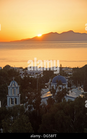 KYKLADEN, GRIECHENLAND. Sonnenaufgang über der ägäischen Insel Anafi, wie gesehen von dem Ferienort Kamari auf Santorini (Thira). Stockfoto