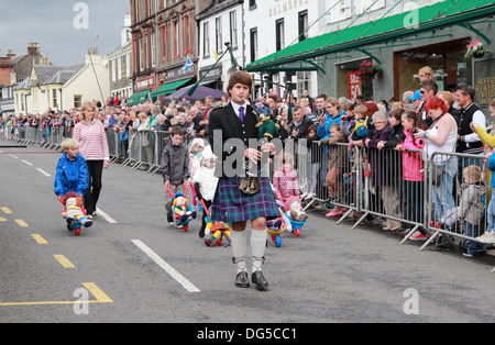 Kaukasischen Mann spielt Dudelsack führt eine Schubkarre Kinderskirennen, Moffat, Dumfries & Galloway, Schottland, UK Stockfoto