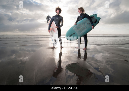 paar am Strand mit Surfbrettern stehend, hat man eine Gopro Kamera Surfbrett Stockfoto