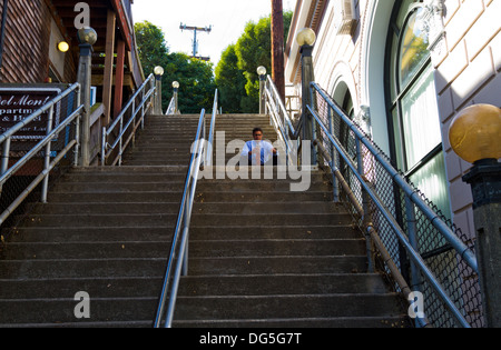 Mann im Anzug in Hemdsärmeln sitzen allein auf Treppe in Sausalito, Kalifornien, eine Tasse Kaffee. Stockfoto