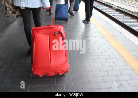 Menschen ziehen Wagen Fällen am Bahnhof Bahnsteig Stockfoto