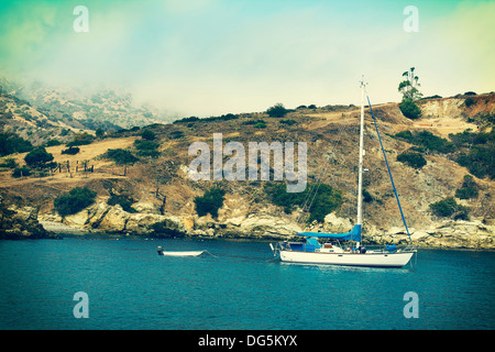 Ein Segelboot und schmuddeligen verankert in einer Bucht auf Catalina Island. Stockfoto