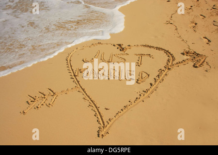 "Just married" im Sand am Strand geschrieben Stockfoto