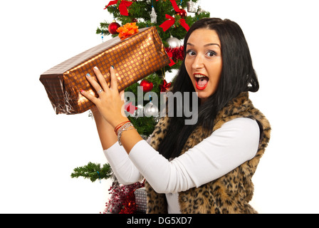 Erstaunt Frau mit Weihnachtsgeschenk vor Baum Stockfoto
