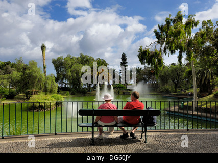 Funchal Madeira, einem mittleren Alters paar sitzt auf einer Bank im Parque de Santa Catarina Stockfoto