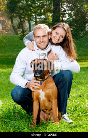 Portrait über ein glückliches junges Paar mit ihrem Hund im Park. Stockfoto