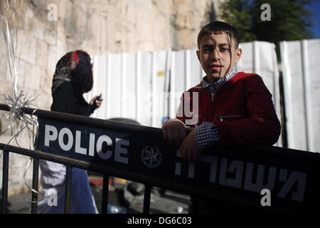 Jerusalem, West Bank, palästinensischen Gebiet. 15. Oktober 2013. Ein palästinensischer Jugendlicher steht auf eine israelische Polizei Barriere vor Damaskus-Tor in der Altstadt von Jerusalem s nach Morgengebet auf der muslimischen Feiertag von Eid al-Adha oder '' Opferfest '' am 15. Oktober 2013. Muslime auf der ganzen Welt feiern das jährliche Festival von Eid al-Adha, das erinnert an die Bereitschaft Abrahams, seinen Sohn Ismail zu Gottes Ehre opfern: Saeed Qaq/APA Images/ZUMAPRESS.com/Alamy Live News Stockfoto