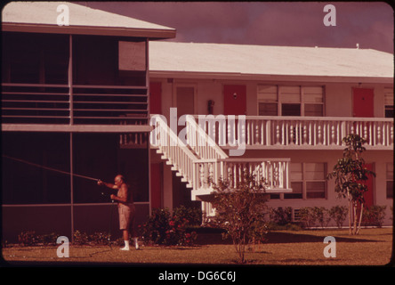 Ein Bewohner der Century Village Rente Community bewässert die Blumen vor seiner Wohnung, was die Betonung der Gemeinde auf die Erhaltung einer angenehmen Umgebung für ihre Bewohner widerspiegelt. Die Seniorengemeinschaft bietet verschiedene Annehmlichkeiten, um älteren Menschen einen komfortablen Lebensstil zu ermöglichen. Stockfoto