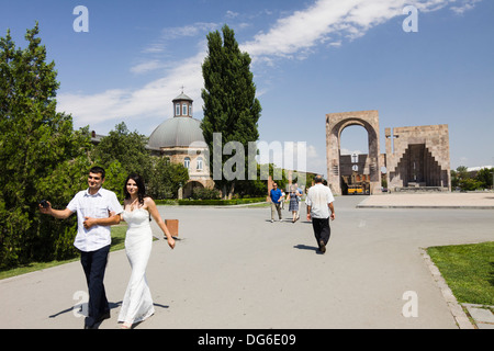 Menschen neben Gevorkian Seminar, Gregor Tor und dem 2001 Papstbesuch Monument´s Open-Air-Altar. Etschmiadsin, Armenien Stockfoto