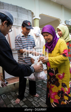 Serpong Banten, Indonesien. 15. Oktober 2013. Die Armen erhielt das Fleisch. Muslime in Indonesien feiern Iedul Adha durch Schlachtung Kühe oder Schafe, den Armen zu geben.  Bildnachweis: Donal Husni/Alamy Live-Nachrichten Stockfoto