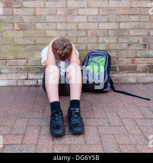 Ein Junge von 10 suchen Sie traurig und deprimiert in seiner Schuluniform zeigt die Auswirkungen von Mobbing im Vereinigten Königreich Stockfoto