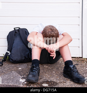 Ein Junge von 10 suchen Sie traurig und deprimiert in seiner Schuluniform zeigt die Auswirkungen von Mobbing im Vereinigten Königreich Stockfoto