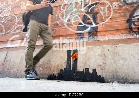 New York, USA. 15. Oktober 2013. Street-Art-Fans strömen in Stadtteil Tribeca New York auf Dienstag, 15. Oktober 2013, der fünfzehnte Ausgabe von Banksy-Graffiti-Kunst, "Tribecca" zu sehen. Die schwer fassbare Streetart-Künstler schafft Werke rund um die Stadt jeden Tag im Laufe des Monats Oktober und dieser Ausgabe zeigt eine Silhouette des World Trade Centers mit einer Blume befestigt. Bildnachweis: Richard Levine/Alamy Live-Nachrichten Stockfoto